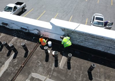 Workers Repairing and Painting Commercial Roof