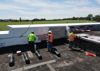 Roofing crew painting a repaired roof